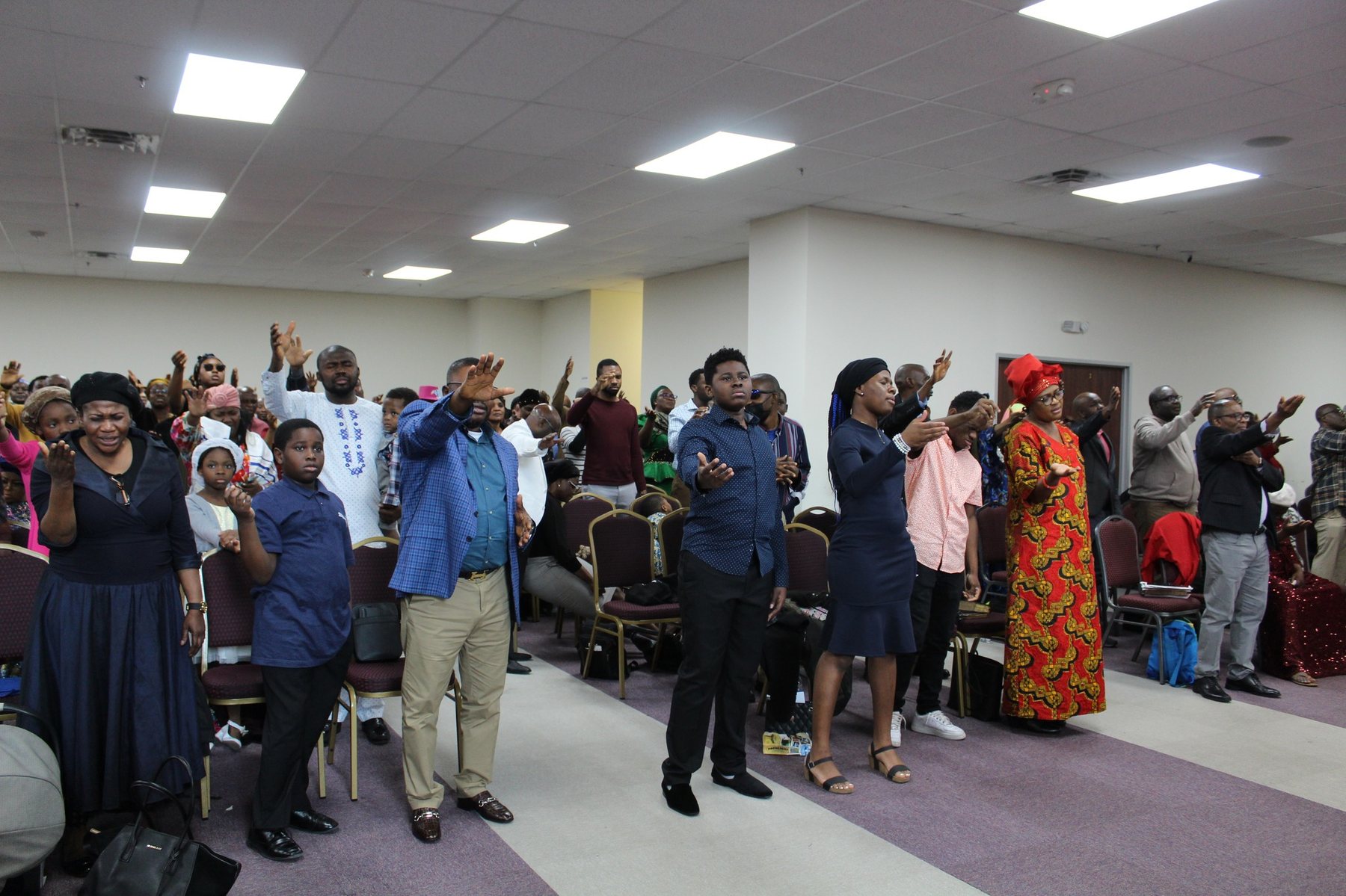 Youth and young adults gathered in worship with hands raised